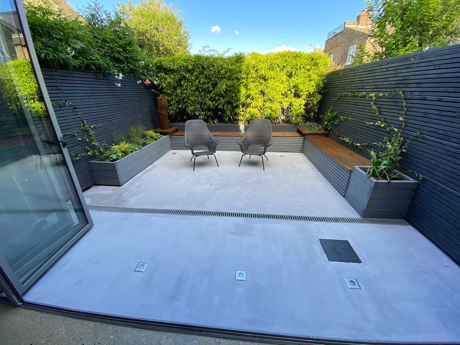 Designed courtyard entertaining area with lounge seating and a clipped hedge